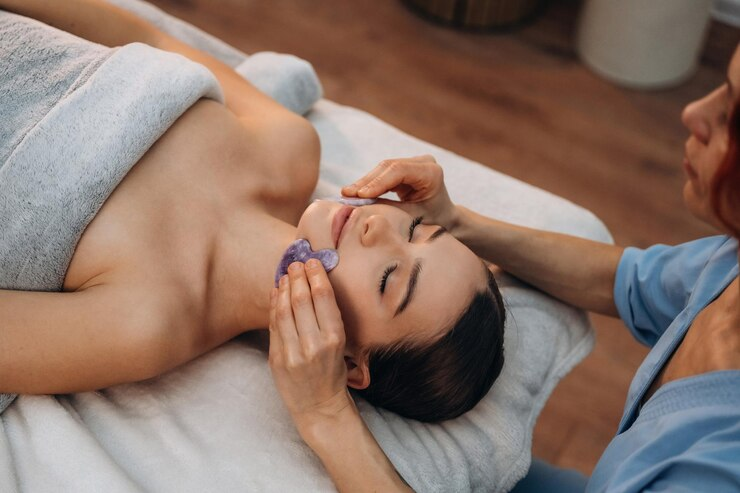 Woman receiving gua sha face massage